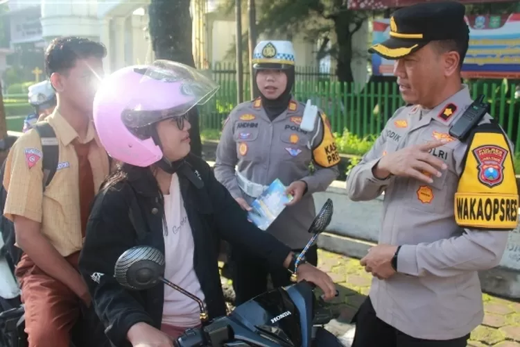 petugas kepolisian saat memberikan hadiah kepada pengendara motor (rizky)