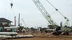 Debu beterbangan, lalu lintas alat berat tak henti-henti, sementara hak mereka masih belum terpenuhi.