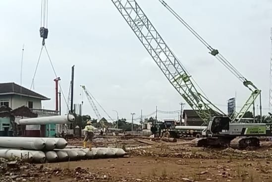 Debu beterbangan, lalu lintas alat berat tak henti-henti, sementara hak mereka masih belum terpenuhi.