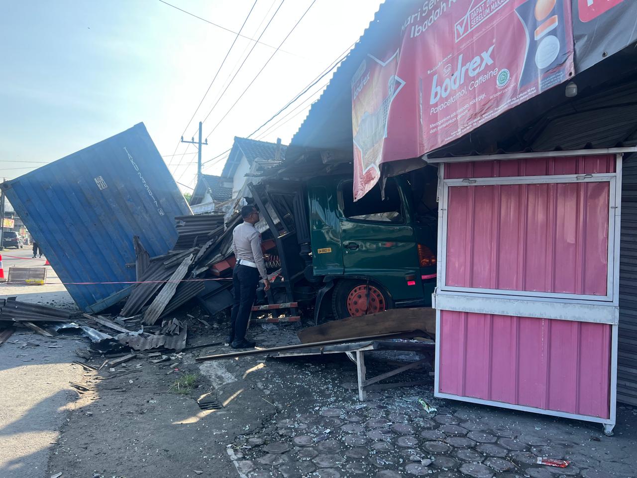 Diduga Sopir Mengantuk, Truk Kontainer Bermuatan Sagu Hantam Drainase dan Teras Toko di Pagu