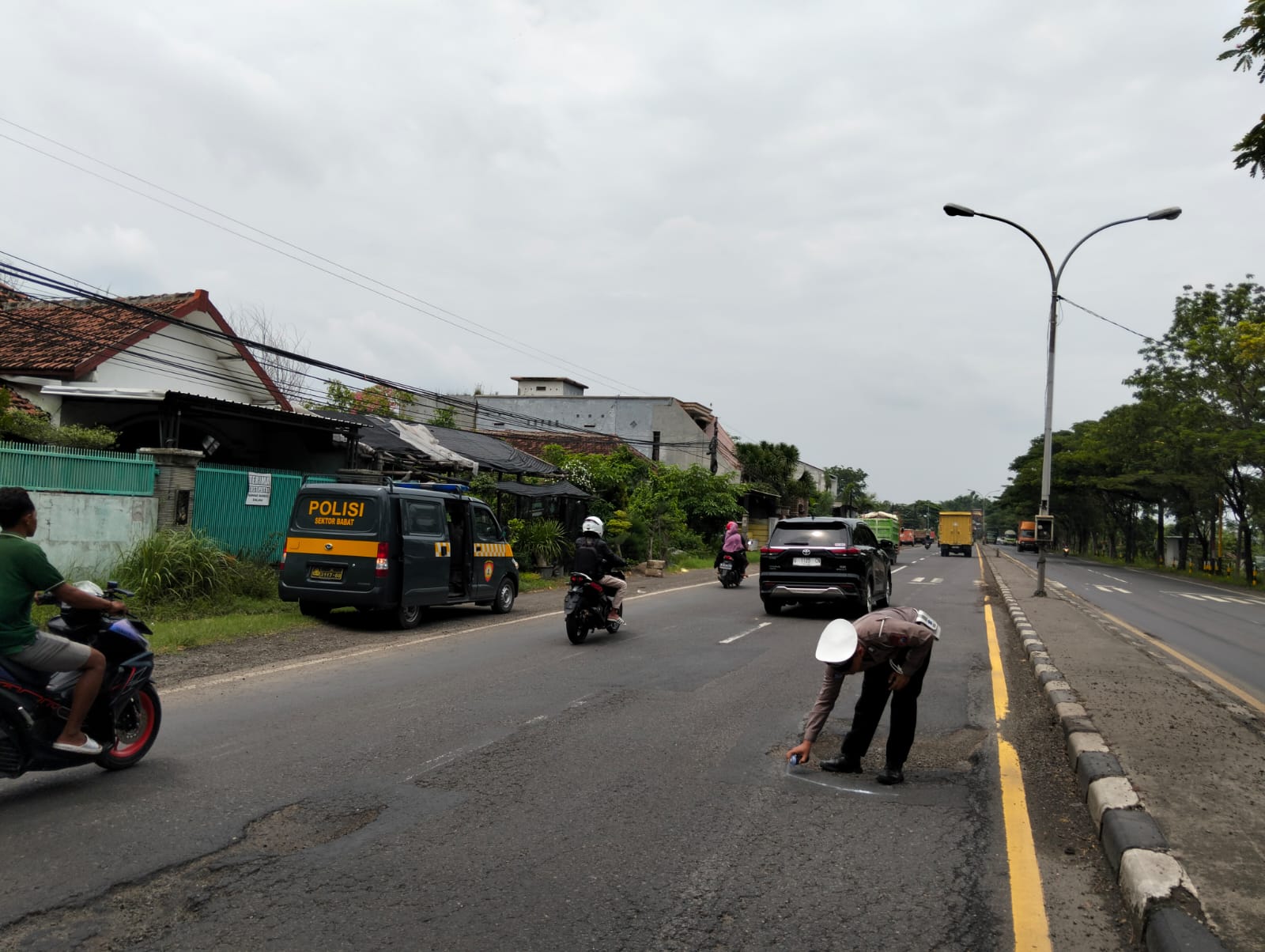 Antisipasi Kecelakaan, Polsek Babat Lamongan Beri Tanda Putih pada Jalan Berlubang
