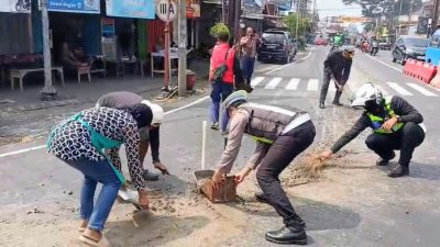 Satlantas Polres Batu Sigap Bersihkan Tumpahan Material Cor di Jalan, Antisipasi Kecelakaan