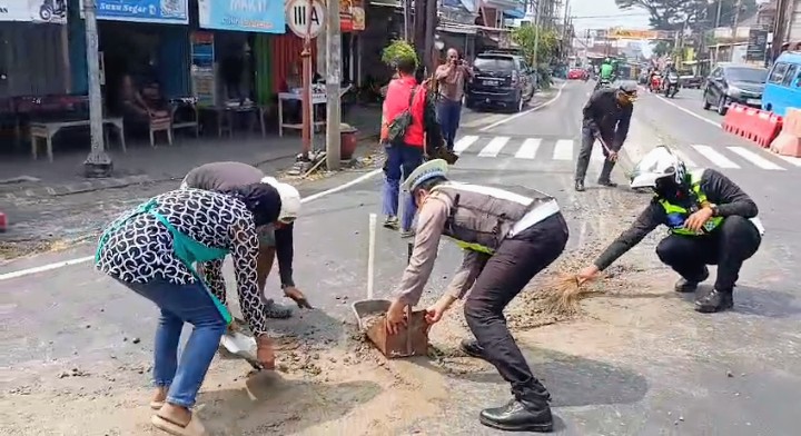 Satlantas Polres Batu Sigap Bersihkan Tumpahan Material Cor di Jalan, Antisipasi Kecelakaan