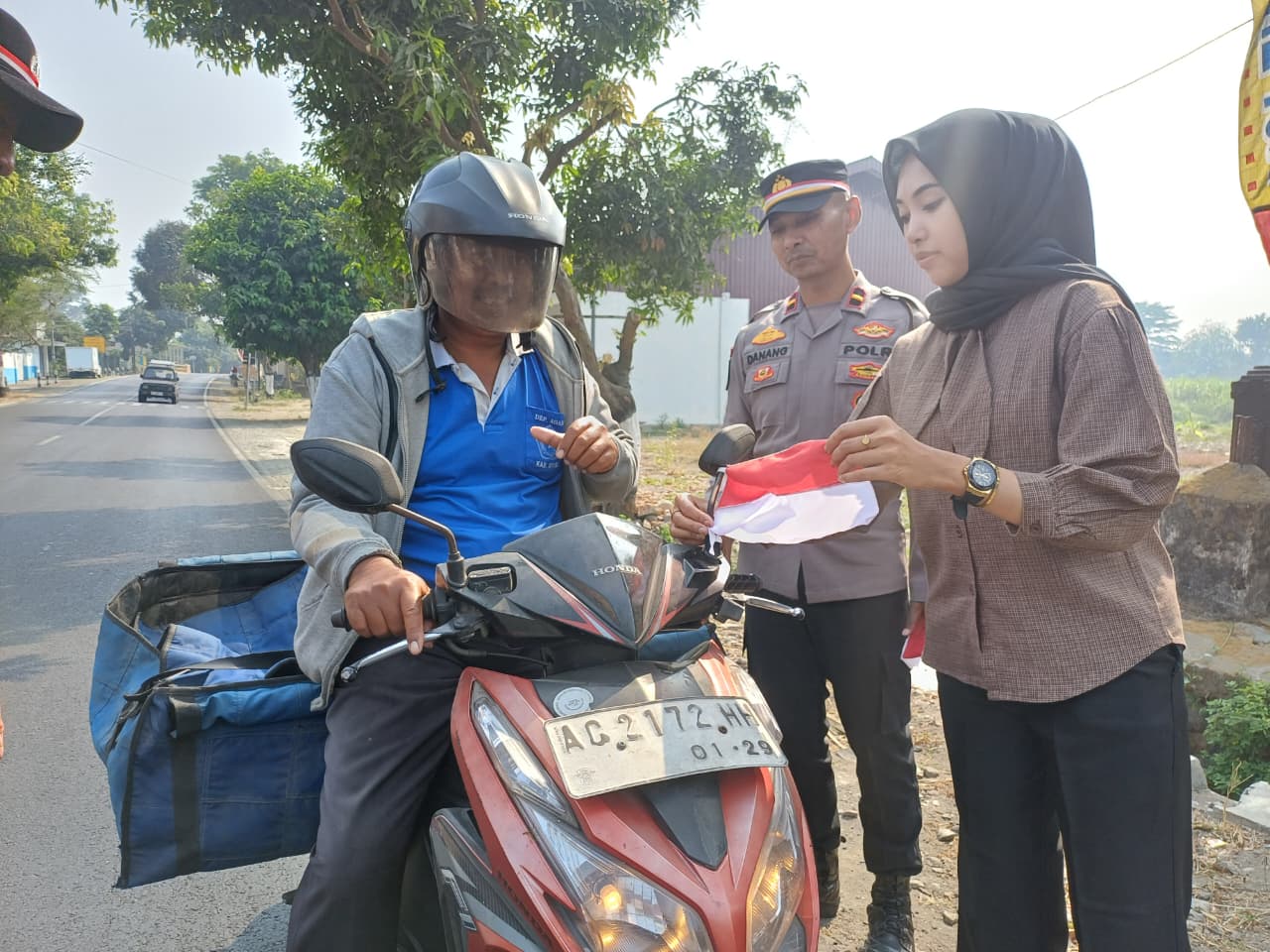 Semarak HUT ke-81 RI, Polsek Kandat Bagikan 81 Bendera Merah Putih kepada Pengguna Jalan
