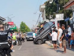 Diduga Salah Masukkan Transmisi, Mobil Pensiunan Nyangkut di Pagar Rumah Warga Jombang