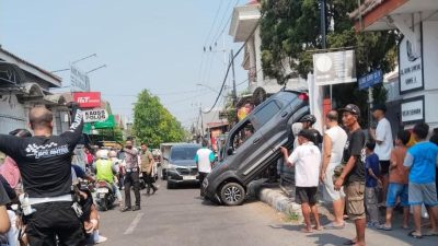 Diduga Salah Masukkan Transmisi, Mobil Pensiunan Nyangkut di Pagar Rumah Warga Jombang