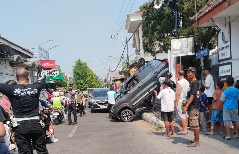 Diduga Salah Masukkan Transmisi, Mobil Pensiunan Nyangkut di Pagar Rumah Warga Jombang