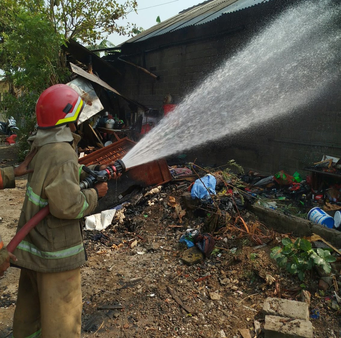 Petugas Damkar Kabupaten Kediri padamkan api yang membakar rumah warga Desa Jong Biru Sabtu siang (ist)